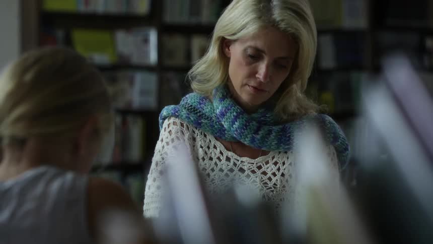 A girl hands a woman a paper