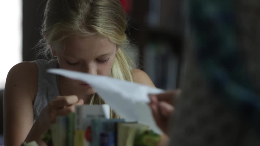 A girl hands a paper over