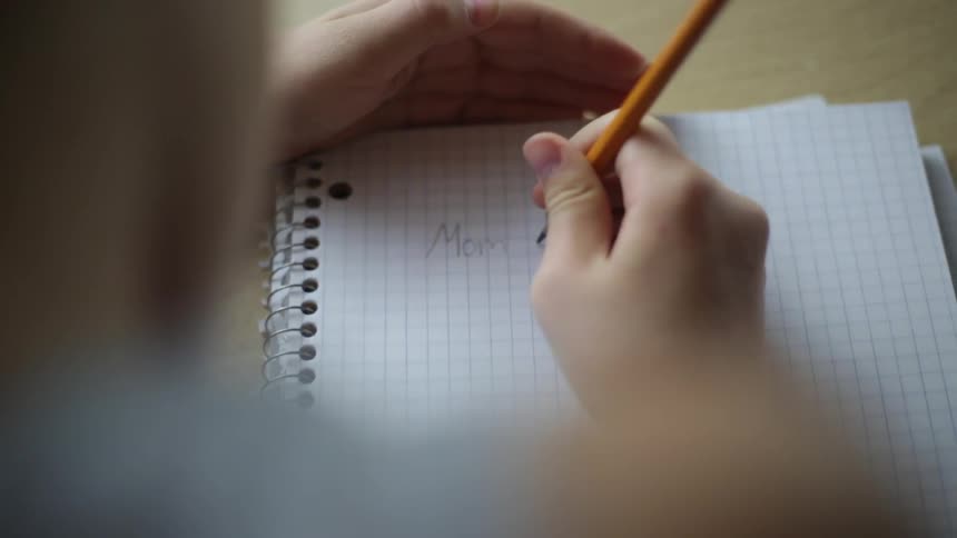 A child is writing in a notebook