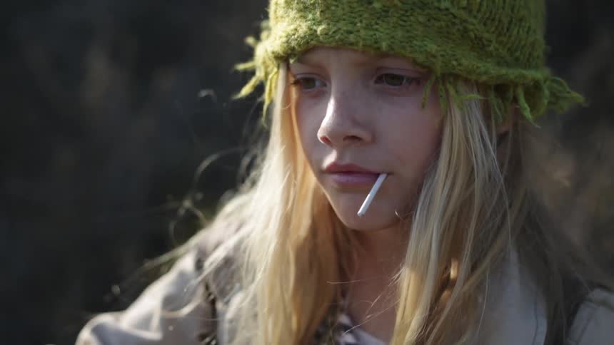A girl is chewing on a small stick