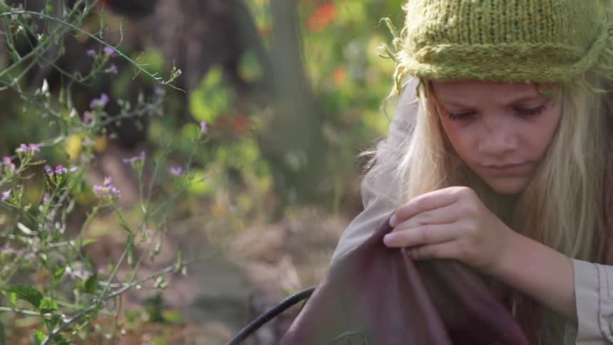 A girl digs through her bag and removes a ring