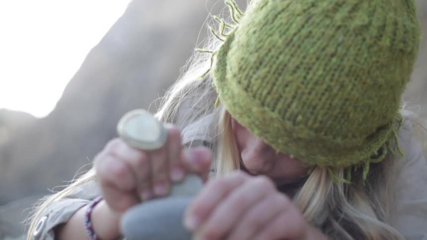 A girl is scraping two rocks together