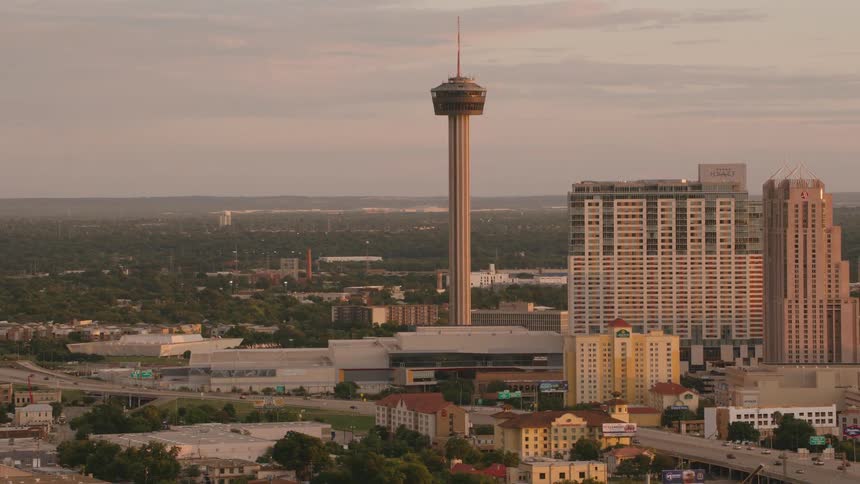 A tower looms over a freeway in a city during the day