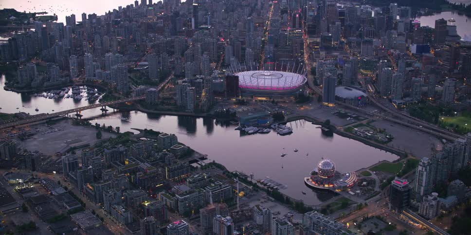 An aerial view of high rise office buildings surrounding a waterway in a city