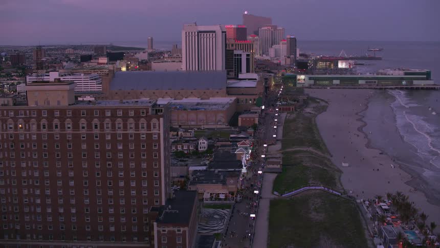 People move along street between beach and hotel and apartment buildings