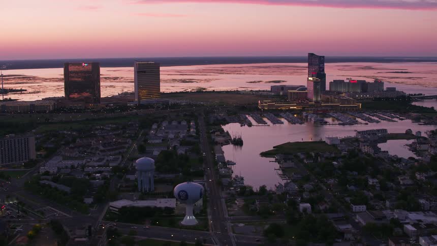 City borders water reflecting the red sky