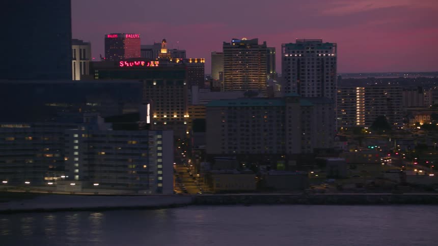Aerial view of high rise buildings next to river against the red sky at dusk