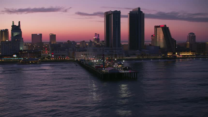 The sun is setting in a city near the ocean