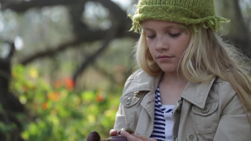 A blonde girl pulls a ring from her bag