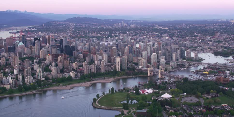 Buildings and skyscrapers surrounding a river in a big city on a hazy day