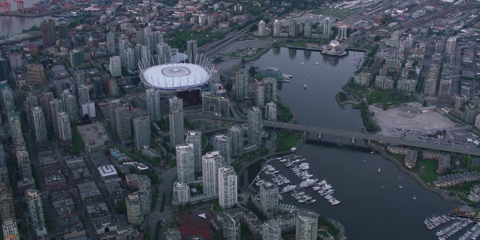 An aerial view of a river running through a city surrounded by high rise offices and apartment buildings