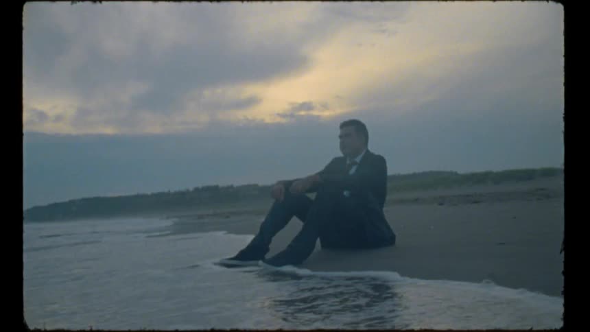A man is sitting on the beach