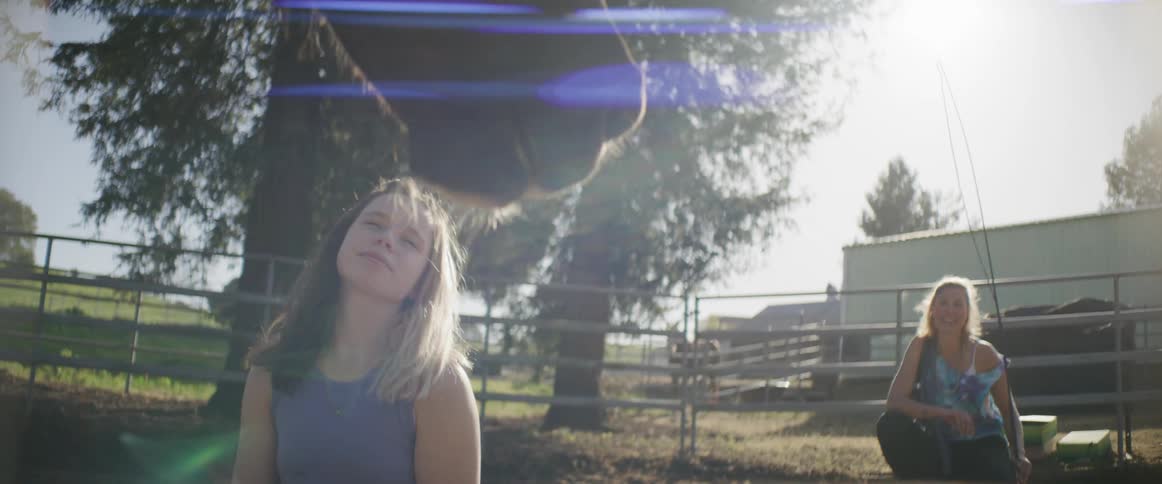 A girl pets a horse that is eating