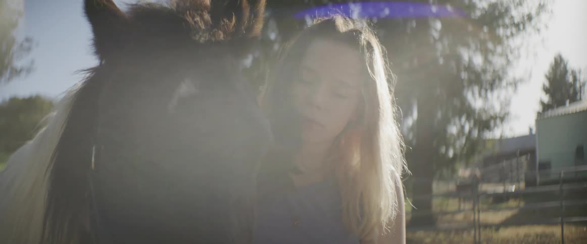 A girl pets and kisses her horse