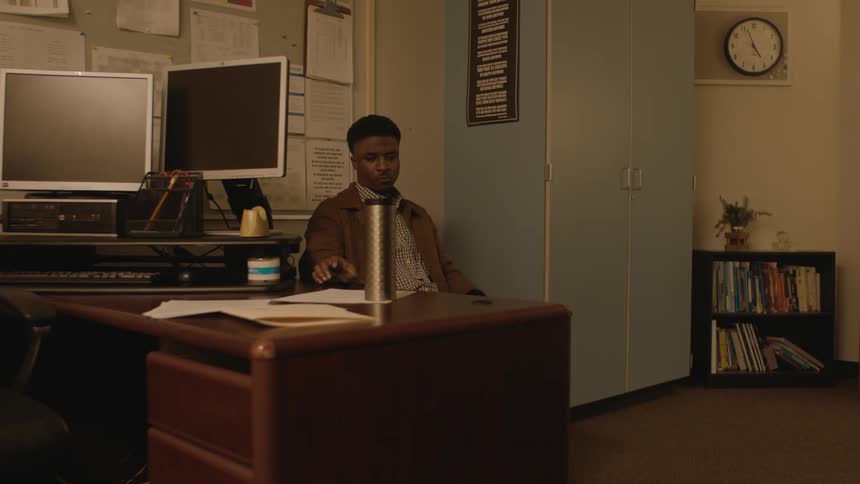 A man is talking on his cell phone in the office