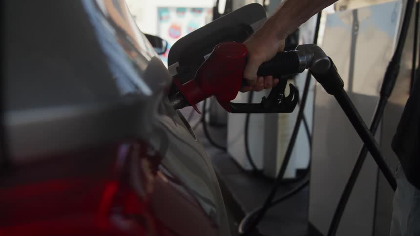 A person fills their car with gas