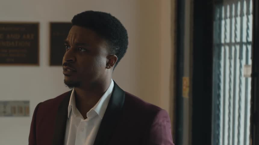 Man argues with another and stands looking angrily after he leaves before putting on a smile and opening the door someone approaching