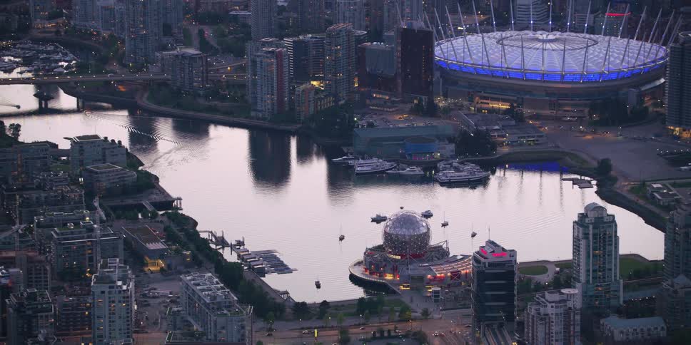 Building topped with sphere sits on channel leading through city to large body of water