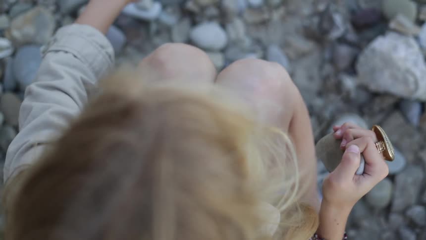 A girl is knocking rocks together