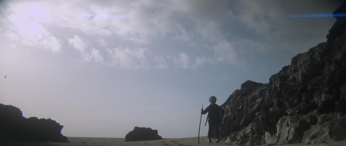 A boy is walking on the sand