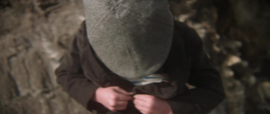 A boy is buttoning his jacket