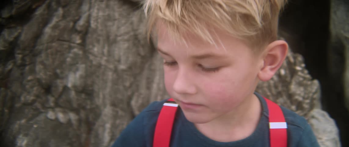 A boy is near some rocks