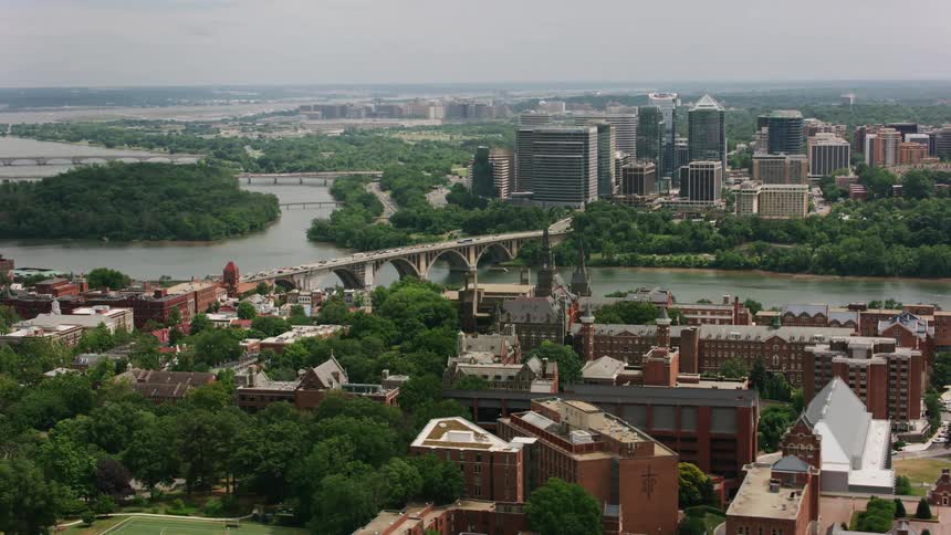 Aerial view of a city near a river is displayed
