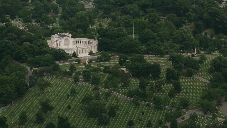 Building with classical architecture stand near cemetery surrounded by woods