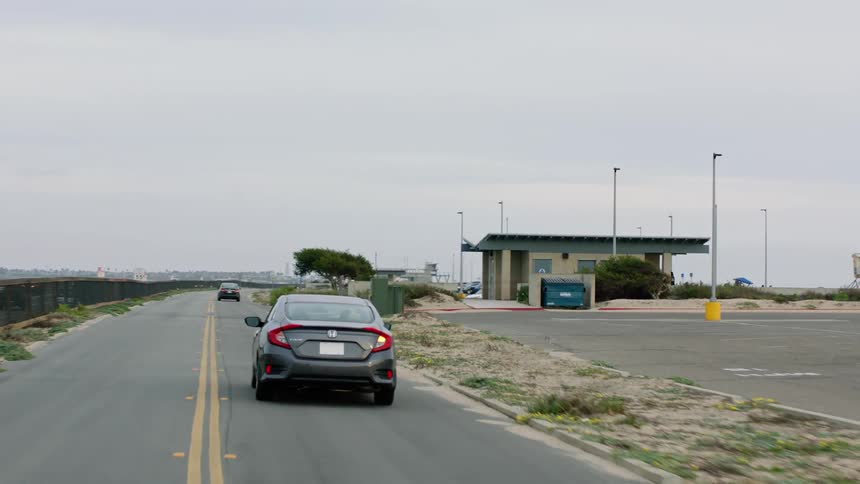 A car puts on its blinker to turn into the beach parking lot