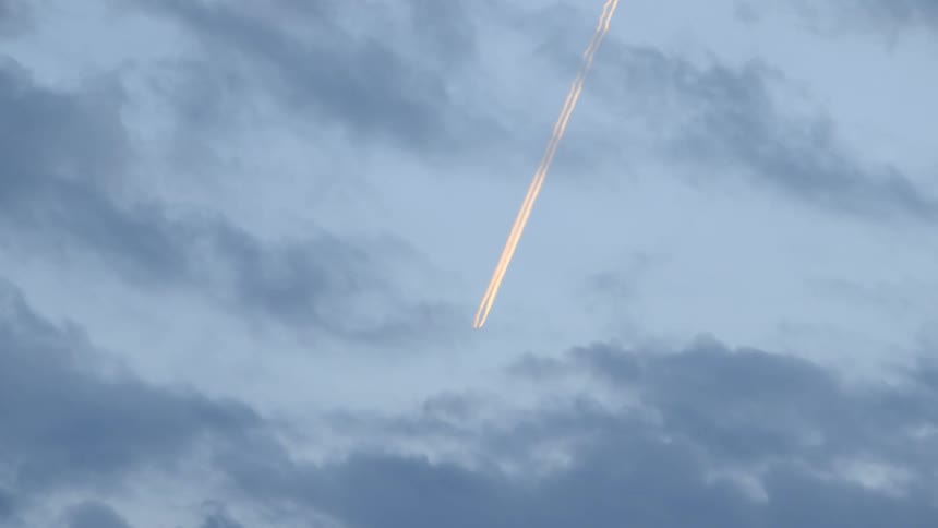 A light is flashing through a cloudy sky above
