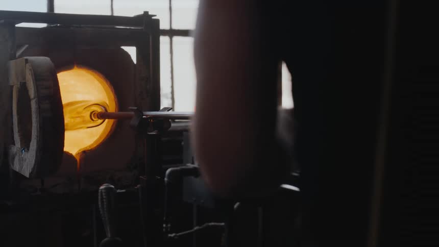 A man is spinning glass in the oven