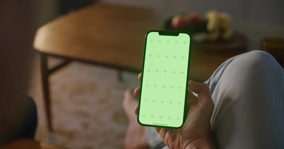 Person sits near coffee table viewing smartphone screen