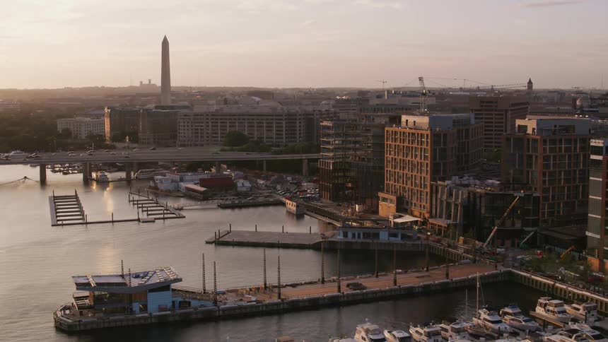 A tall obelisk looms over the coastline of a city during the day