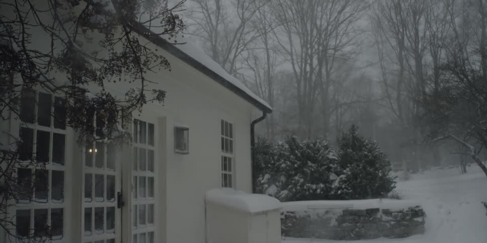 The facade of a house during a snowstorm on a winter day