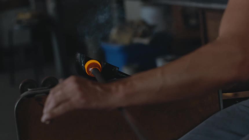 Glass maker shapes molten glass