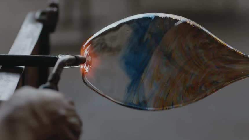 A glass maker is using a torch