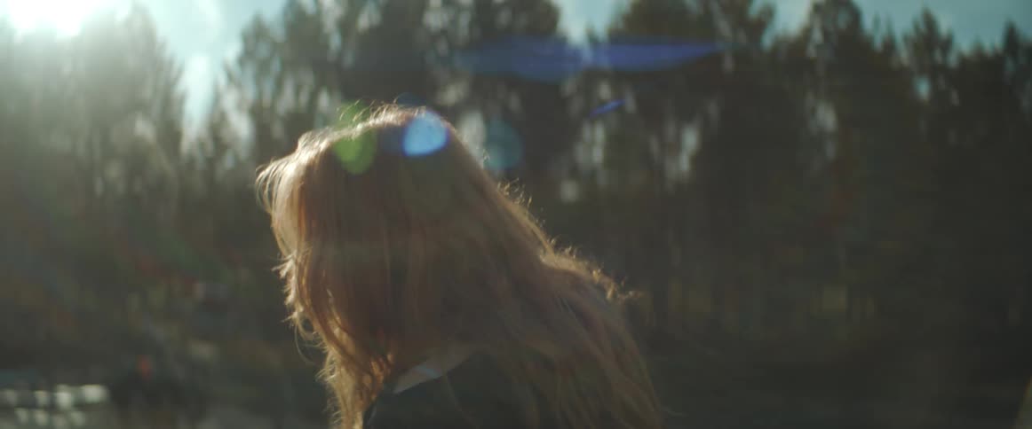 A woman dances outdoors in a field during the day