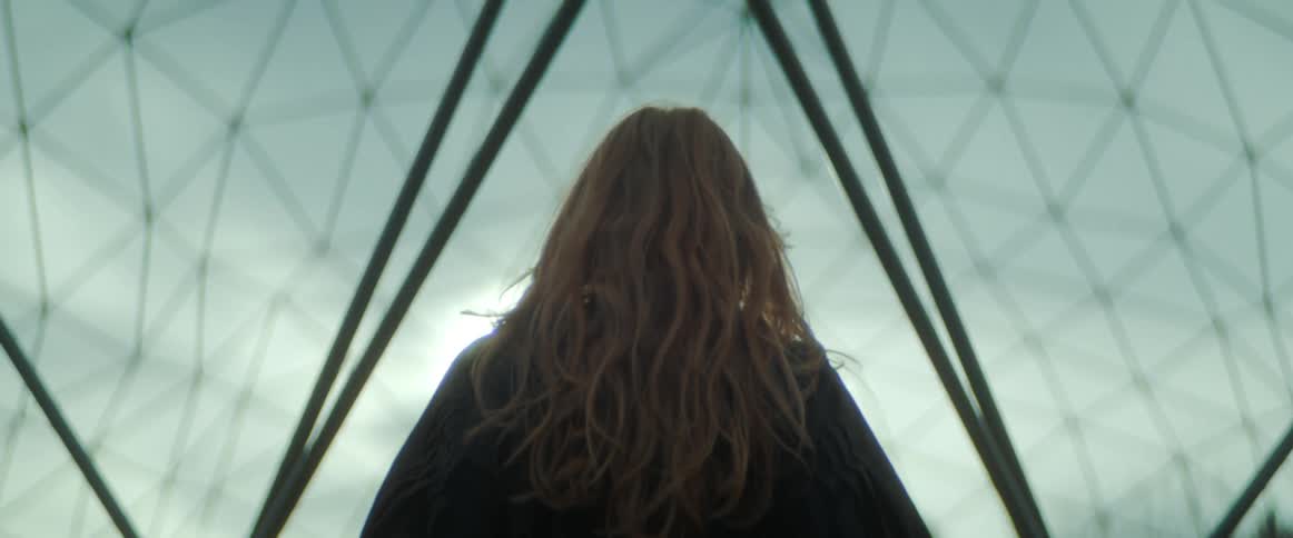A woman is walking outdoors in the wilderness at dusk