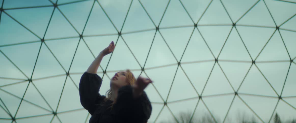 A woman dances under a jungle gym