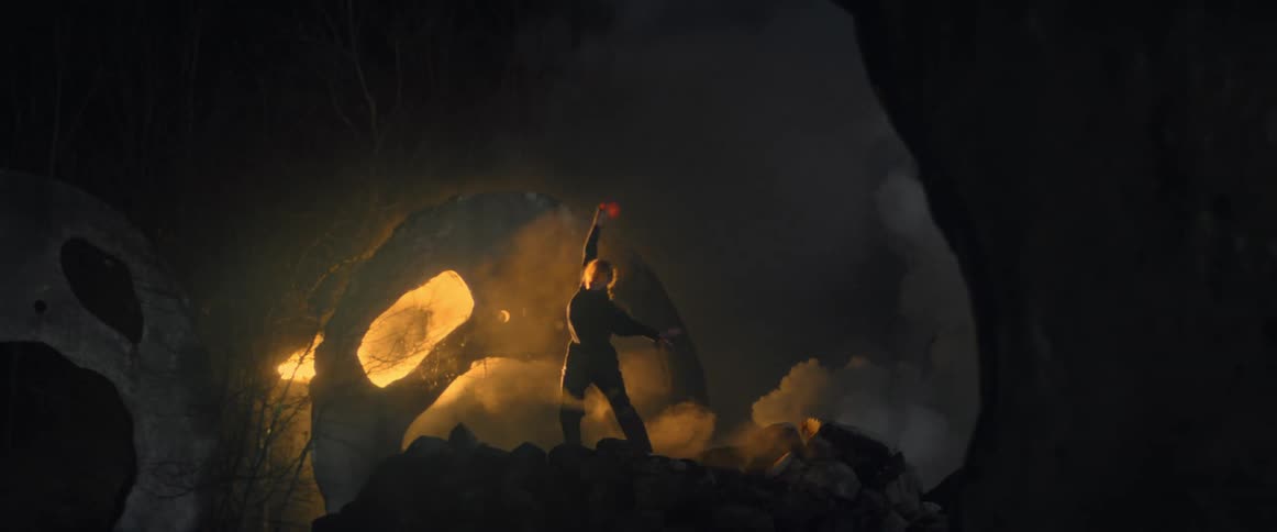 Woman is dancing alone in a forest at night with flames