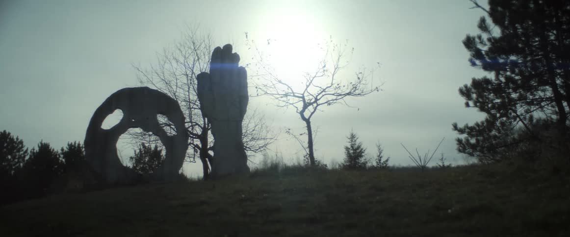 A landscape with monuments is displayed at dusk
