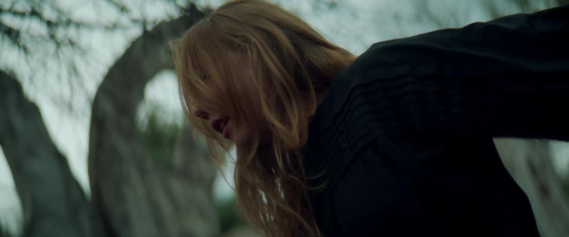 A female is dancing outdoors in a forest