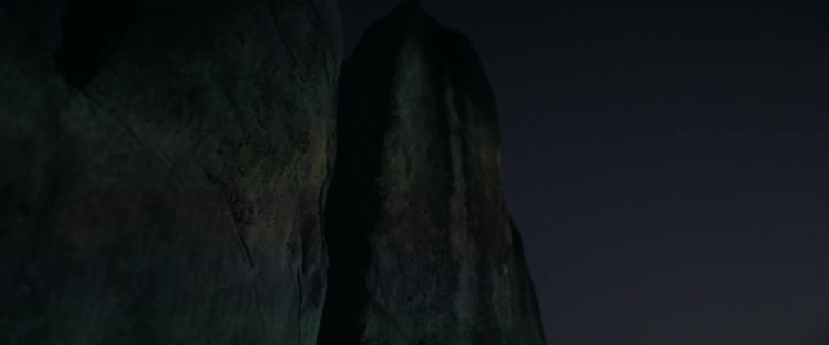 Light show reflecting on the surface of a sculpture at night