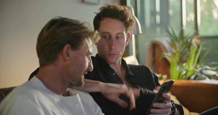 Two men looking at a cell phone and laughing