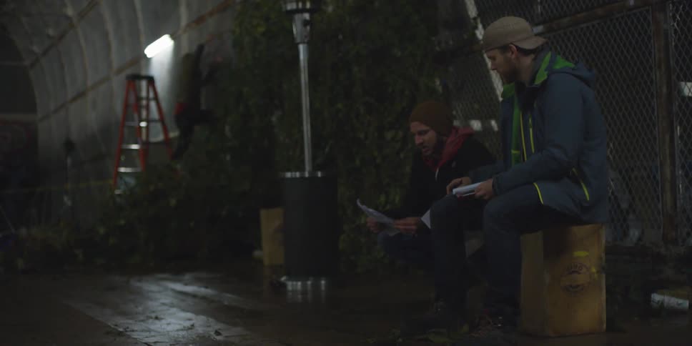 Two people are flipping through some papers and talking