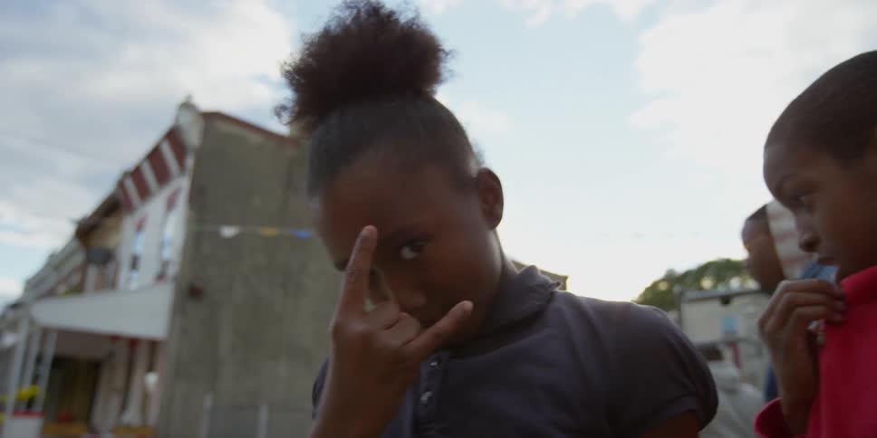 A girl gives horn signs on a cloudy day