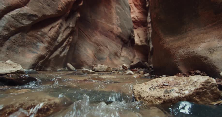 Clear river water flowing over rocks and stones in a canyon