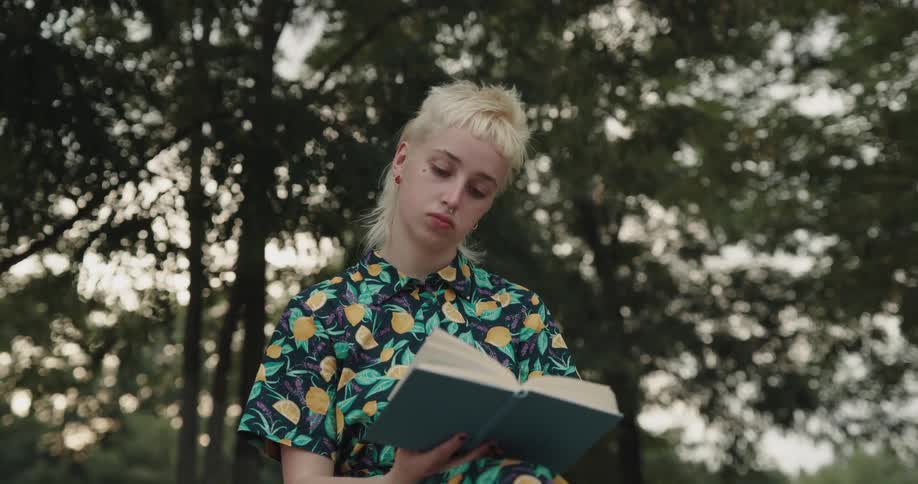 A woman sits outside and reads a book
