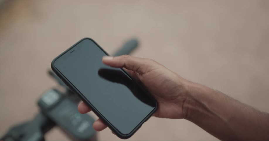 Someone is holding a cellphone in their hand and moving their thumb across the screen