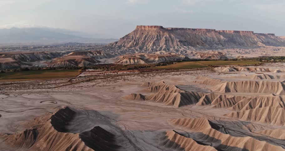 Mountains and mesa in the desert badlands under a hazy sky